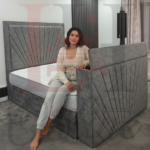 Modern grey sunburst upholstered TV bed with electric lift mechanism in a contemporary bedroom.