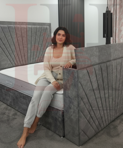 Modern grey sunburst upholstered TV bed with electric lift mechanism in a contemporary bedroom.