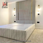 Tall floor standing headboard bed in cream velvet with gold metal strips