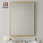 Simple rectangular gold bathroom vanity mirror above sink.