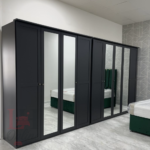 Chalet black mirrored wardrobe with 5 doors in a modern bedroom setting.